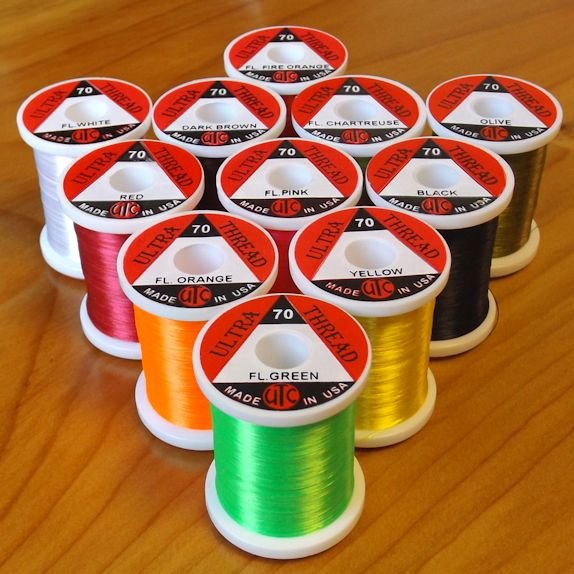 Assorted UTC fly-tying thread spools in multiple deniers (70, 140, 210, GSP) and colors—strong, smooth nylon and gel-spun options for tying trout, salmon, and saltwater flies.